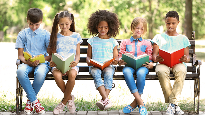 Children reading books on a bench