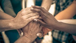 Various hands making a pile