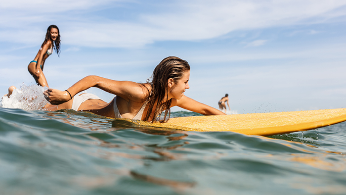 Woman paddling to catch a wave