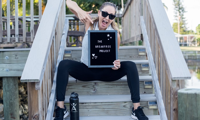 Sandra holding a sign that says The Break Free Project