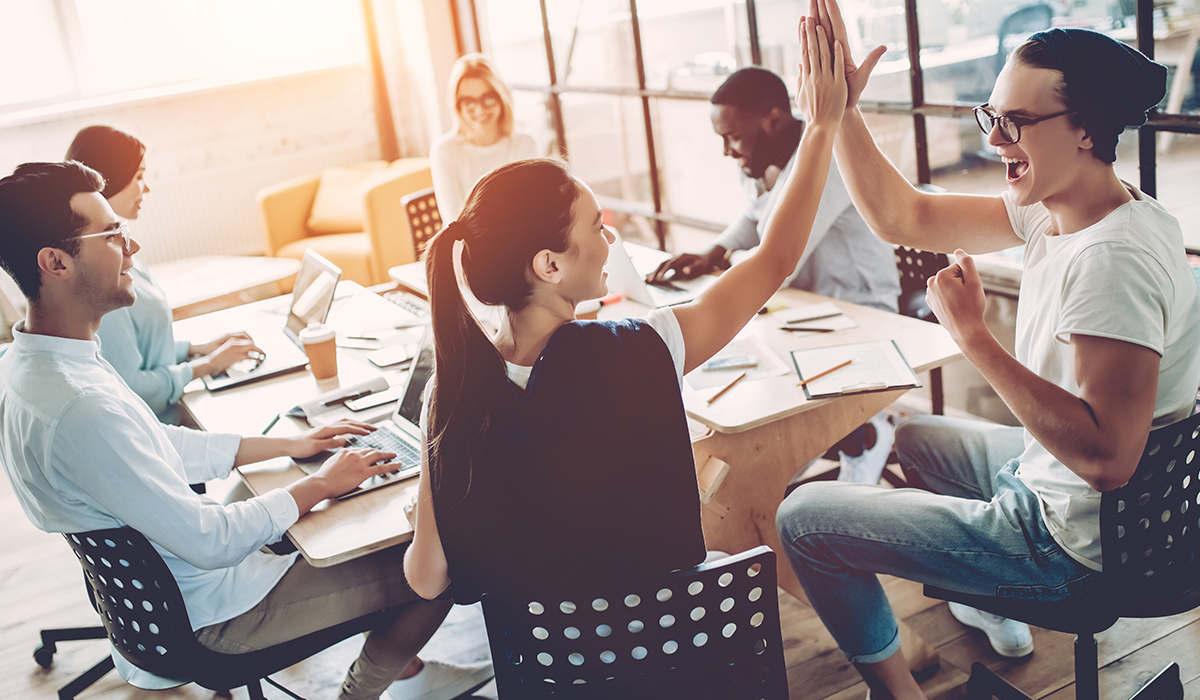 A group of people high-fiving and working