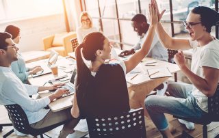 Two people high-fiving at a meeting