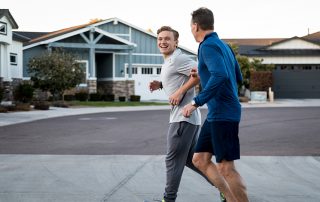 Father and adult son exercising on a neighborhood street
