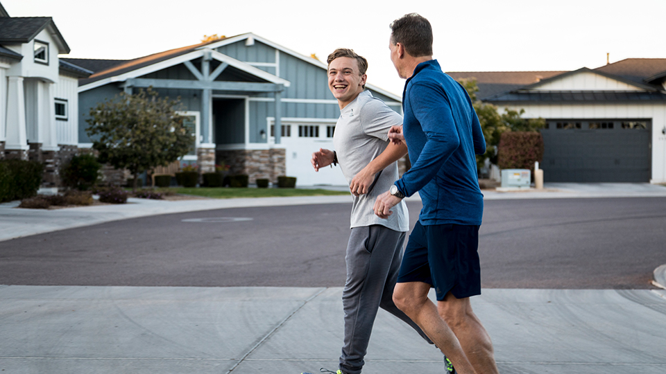 Father and adult son exercising on a neighborhood street
