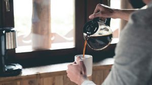 Someone pouring coffee into a mug