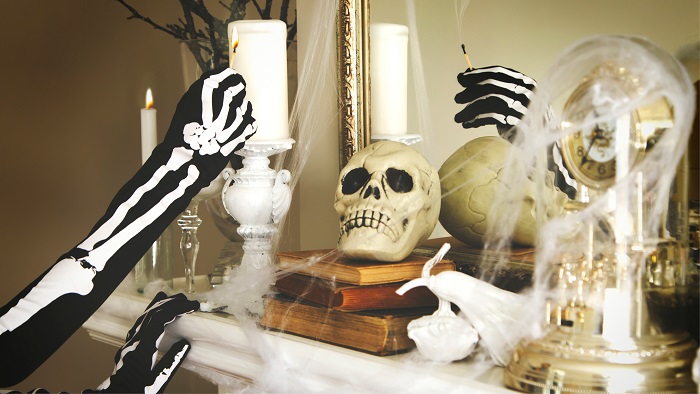 Skeleton man lights skeleton match over skeleton head