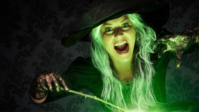 A witch holding a wand with a green glow