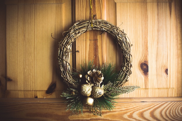 A wooden Christmas wreath with gold ornaments