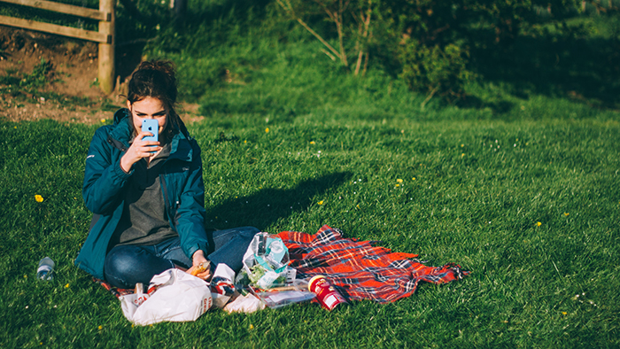 Woman video chatting on her cell phone at the park