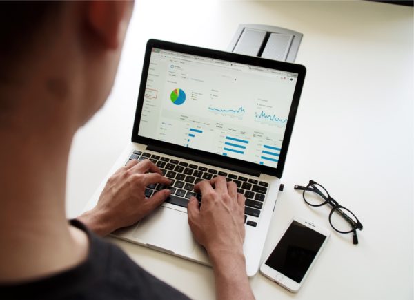 Man looking at graphs and charts on a laptop