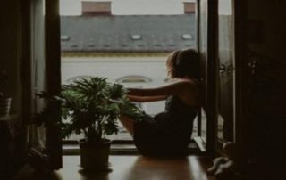 Woman sitting by open windows