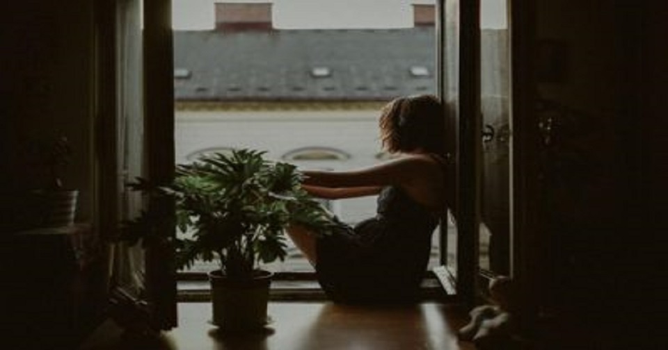 Woman sitting by open windows