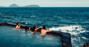 Four people swimming by the ocean