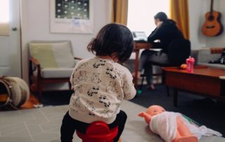 little girl playing while mom works