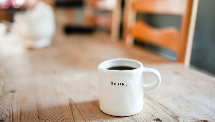 White coffee mug with the word "begin" on it