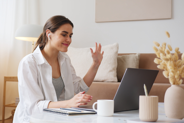 Woman waving goodbye to her laptop