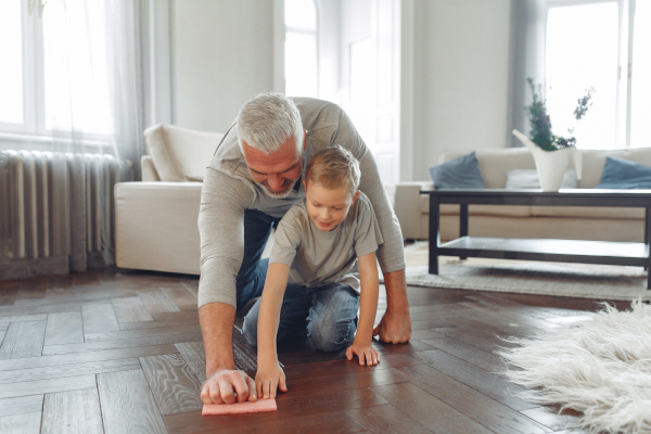 A man and a boy scrubbing the floor