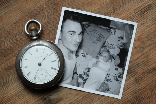 Pocket watch and black-and-white photo of father holding a baby